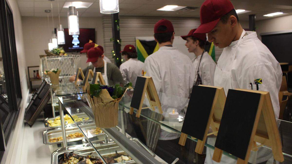 Students in State College Area High School’s culinary arts program prepare for a community dinner featuring Jamaican foods.