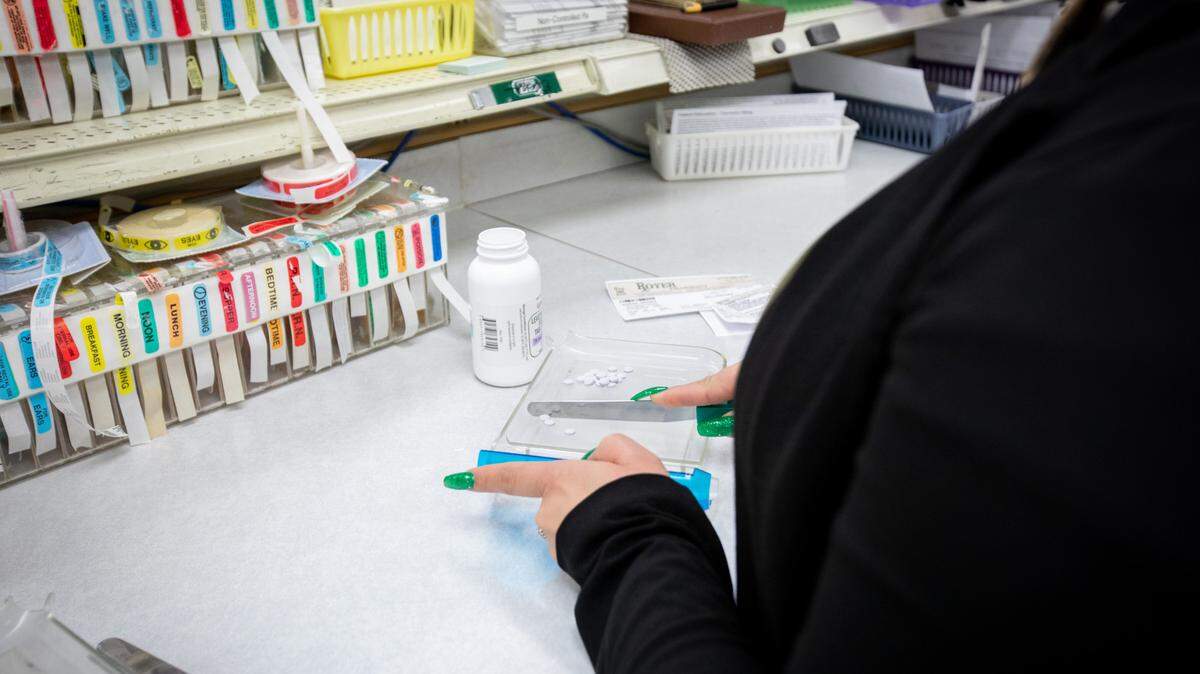 A pharmacy worker prepares a prescription.