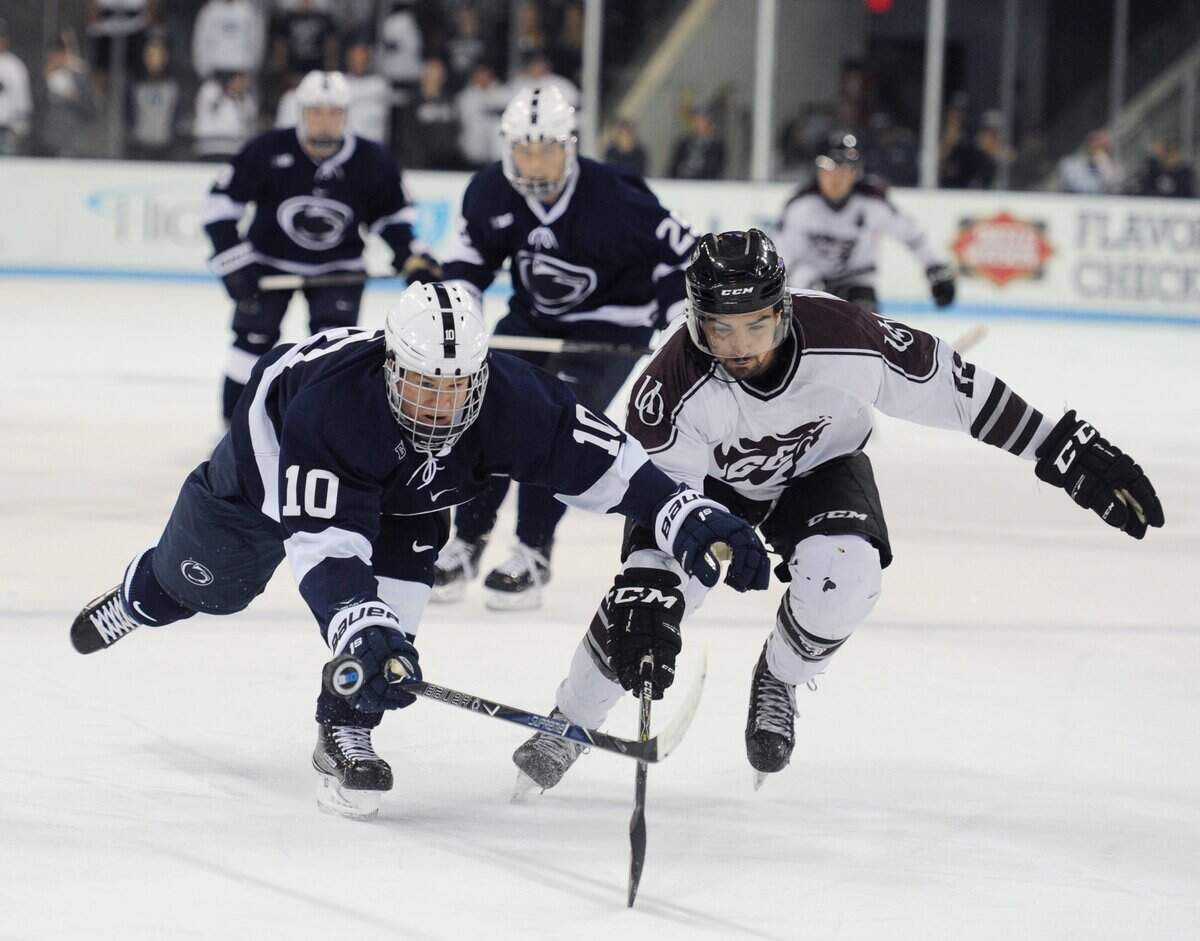 Penn State forward Brandon Biro, left, and Ottawa defender Jean-Robin Mantha both dive toward the puck during a 2017 exhibition game against Ottawa at Pegula Ice Arena.