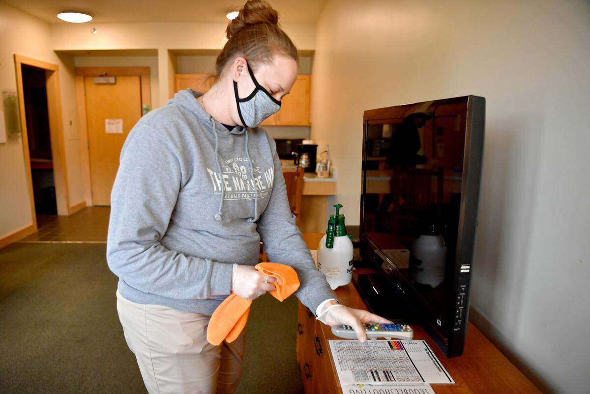 Miranda Jukes sanitizes and cleans a room at The Nature Inn at Bald Eagle State Park on Friday, Jan. 29, 2021.