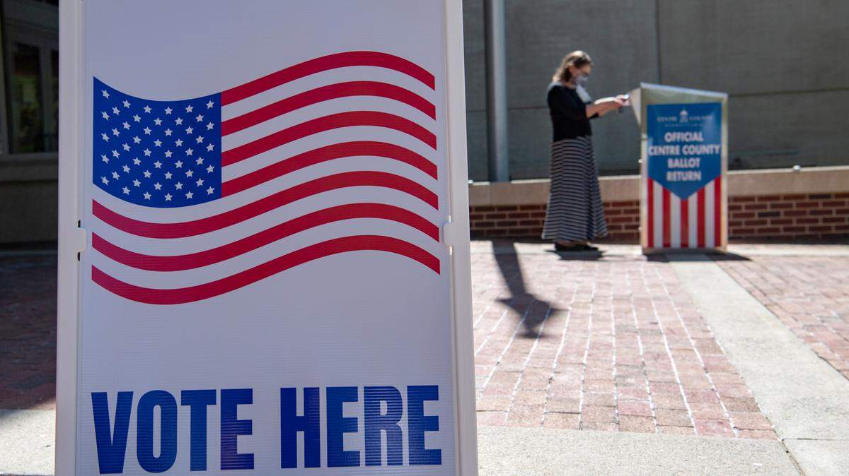 A voter places their ballot for the primary election in the drop box outside of the State College Municipal Building on Tuesday.