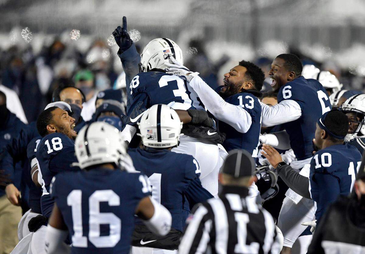 Penn State safety Lamont Wade is lifted and congratulated by his teammates after his touchdown in the first quarter of the game against Illinois on Saturday, Dec. 19, 2020 at Beaver Stadium.