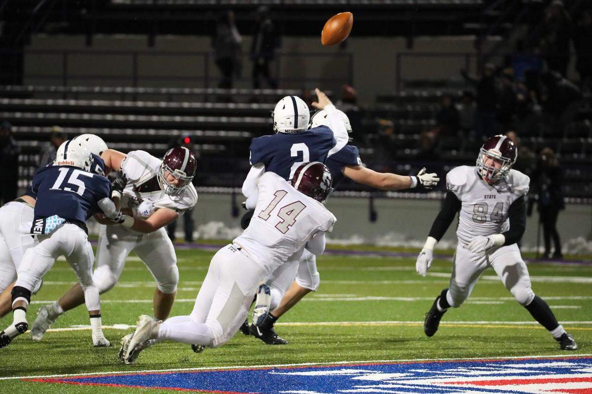 State College Kevin Kurzinger pulls down McDowell QB Chris Juchno on Friday in the PIAA Class 6A subregional football game at Erie Veterans Memorial Stadium. State College won 42-21.