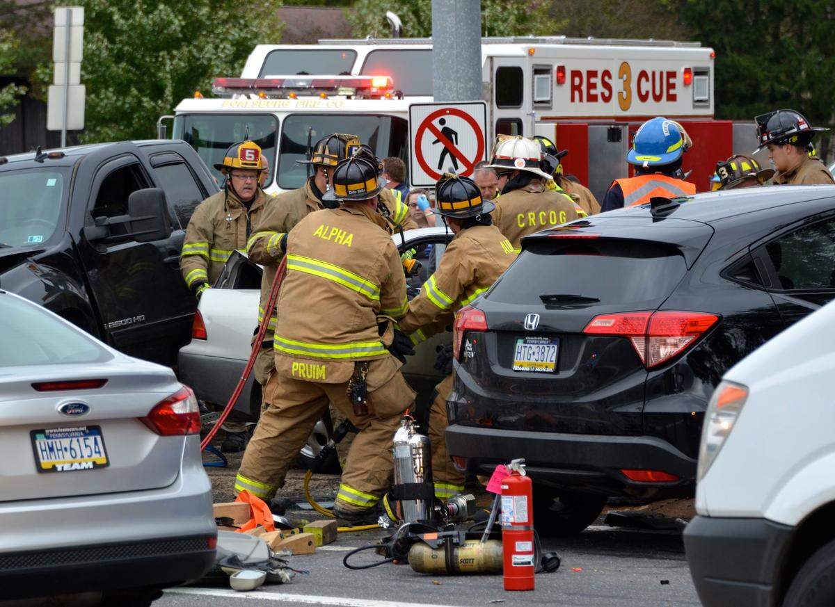 Boalsburg and Alpha firefighters remove a car door to extricate a patient at the scene of a multi-vehicle crash at the intersection of Shingletown road and South Atherton Street in Harris Township on Friday morning.