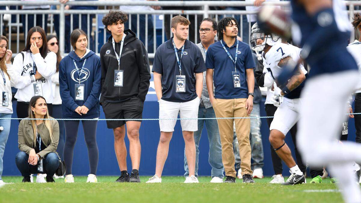 Wearing a black Penn State zip-up, football recruit Tony Rojas watches the players warm up for the the Blue-White game on Saturday, April 23, 2022.