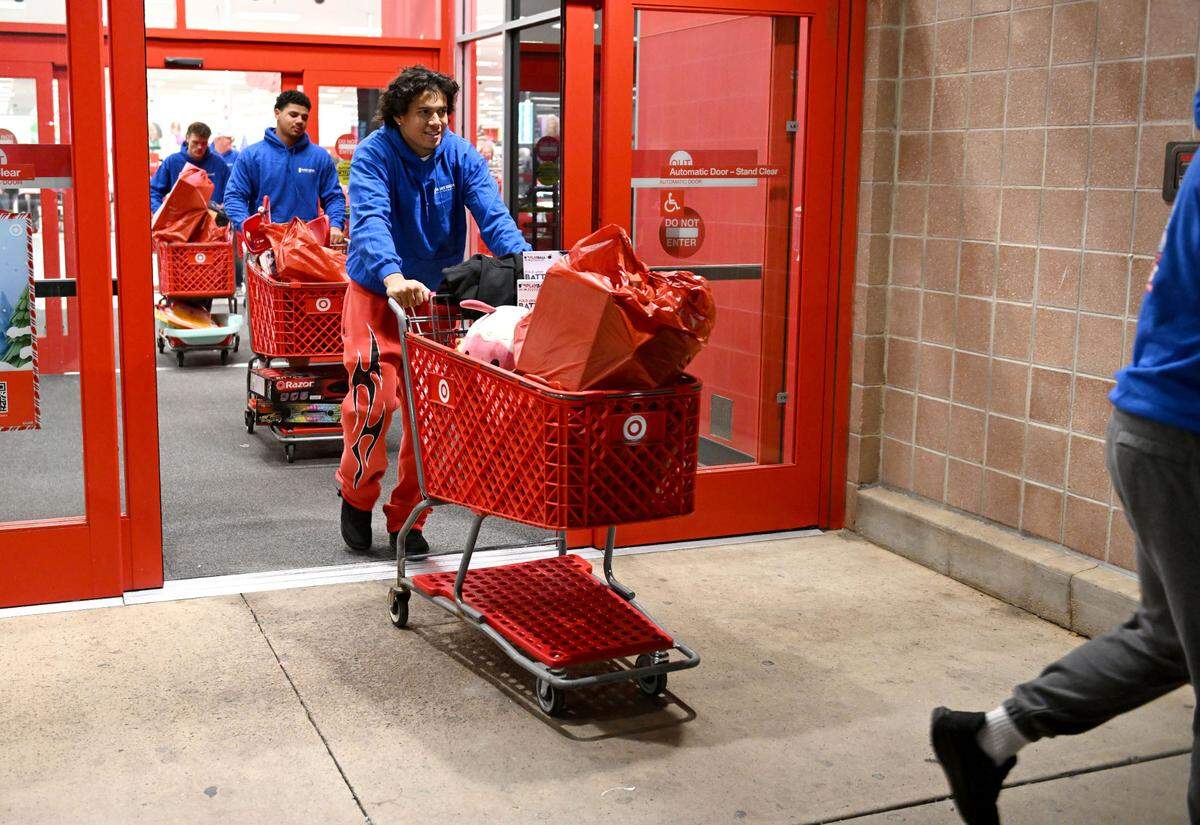 Penn State linebacker Tony Rojas pushes a cart full of gifts to out of Target after a shopping spree for Toys for Tots with West Shore Home on Monday, Dec. 2, 2024.