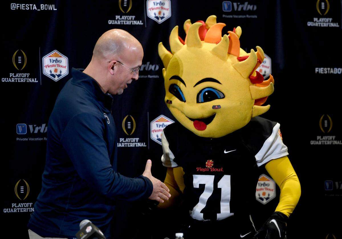 Penn State football coach James Franklin shakes hands with the Fiesta Bowl mascot Spirit during media day for the Fiesta Bowl on Sunday, Dec. 29, 2024.
