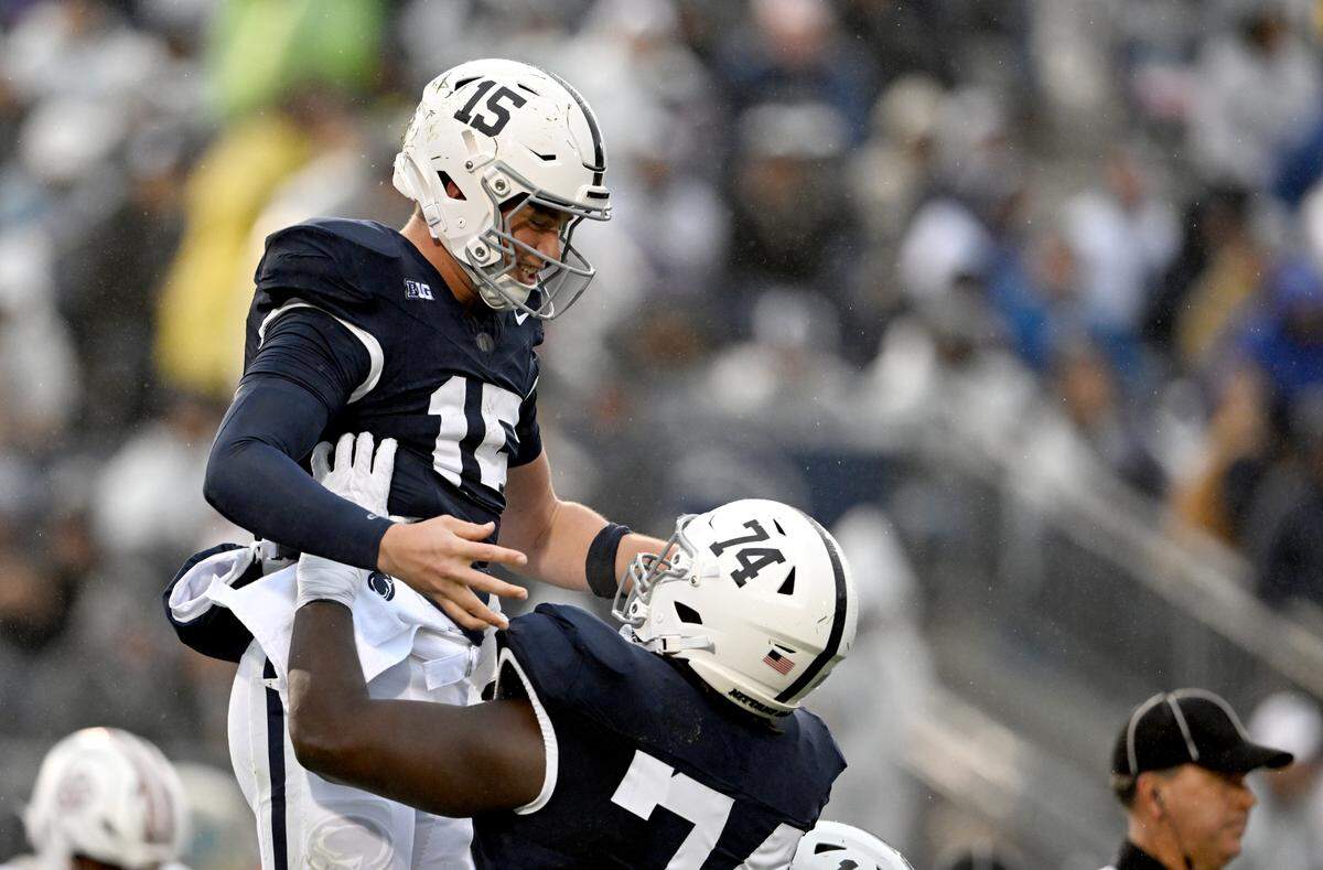 Penn State offensive lineman Olumuyiwa Fashanu lifts up quarterback Drew Allar to celebrate his touchdown during the game against UMass on Saturday, Oct. 14, 2023.