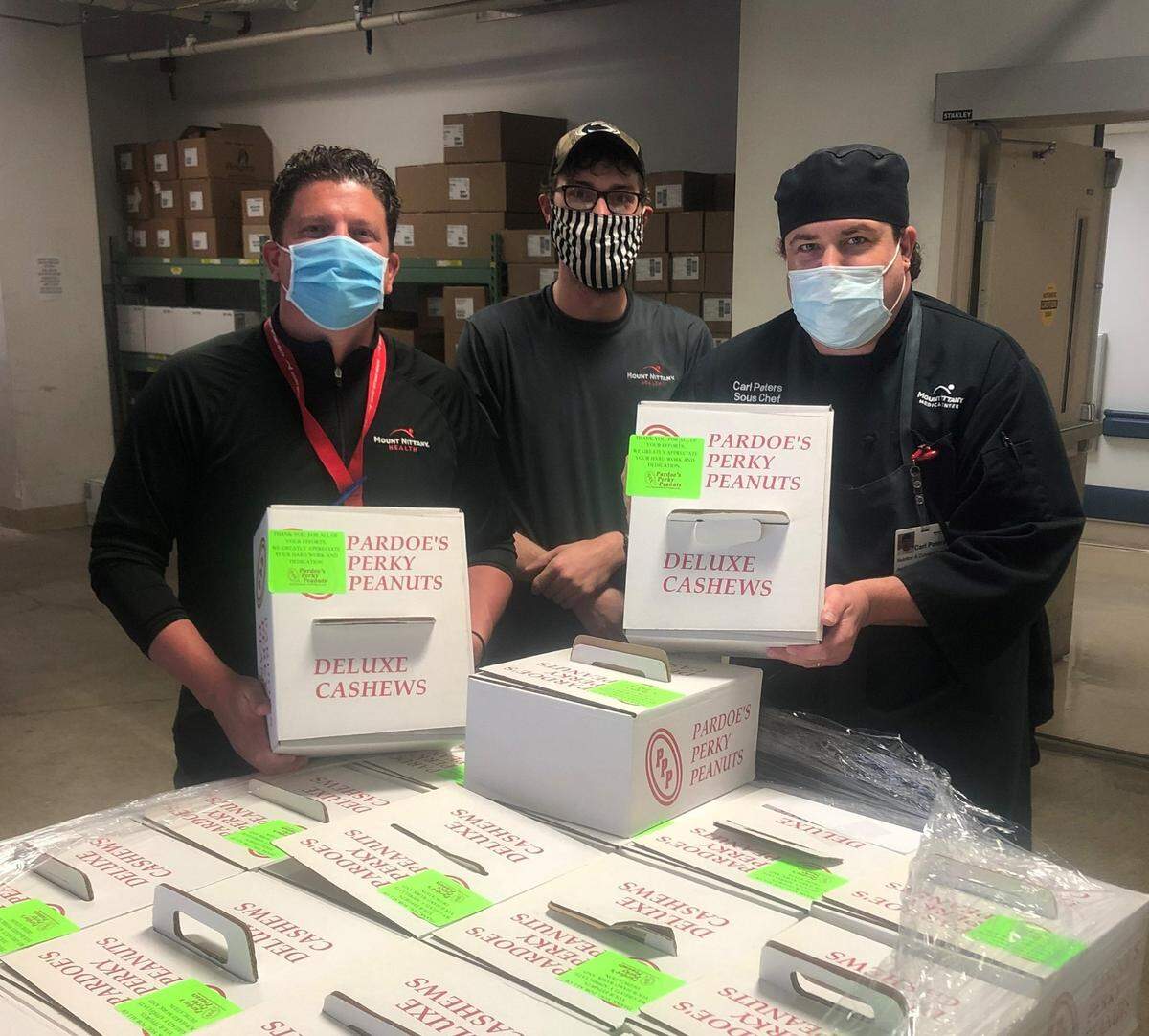 Mount Nittany Medical Center’s Culinary Services manager Craig Hamilton, from left, Ethan Lidgett, of supply chain, and sous-chef Carl Peters unpack boxes of peanuts and cashews donated by Pardoe’s Perky Peanuts, of Northumberland County.