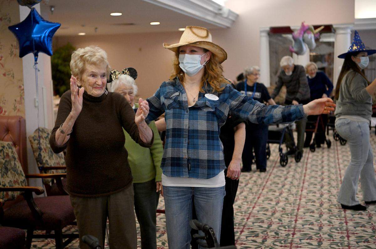 Gwen Bunnell claps along to “LocoMotion” as she dances around the room with fellow residents of Juniper Village at Brookline senior living on Monday. Residents danced for 46 minutes as part of a mini-Thon to raise money the Four Diamonds Fund and celebrate Penn State’s 46 hour dance marathon.