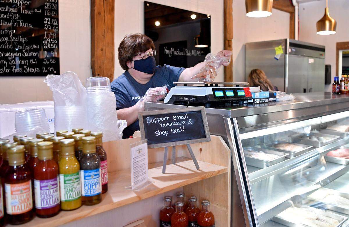Peggy Brooks weighs shrimp for a customer at Maine Bay & Berry on Tuesday.