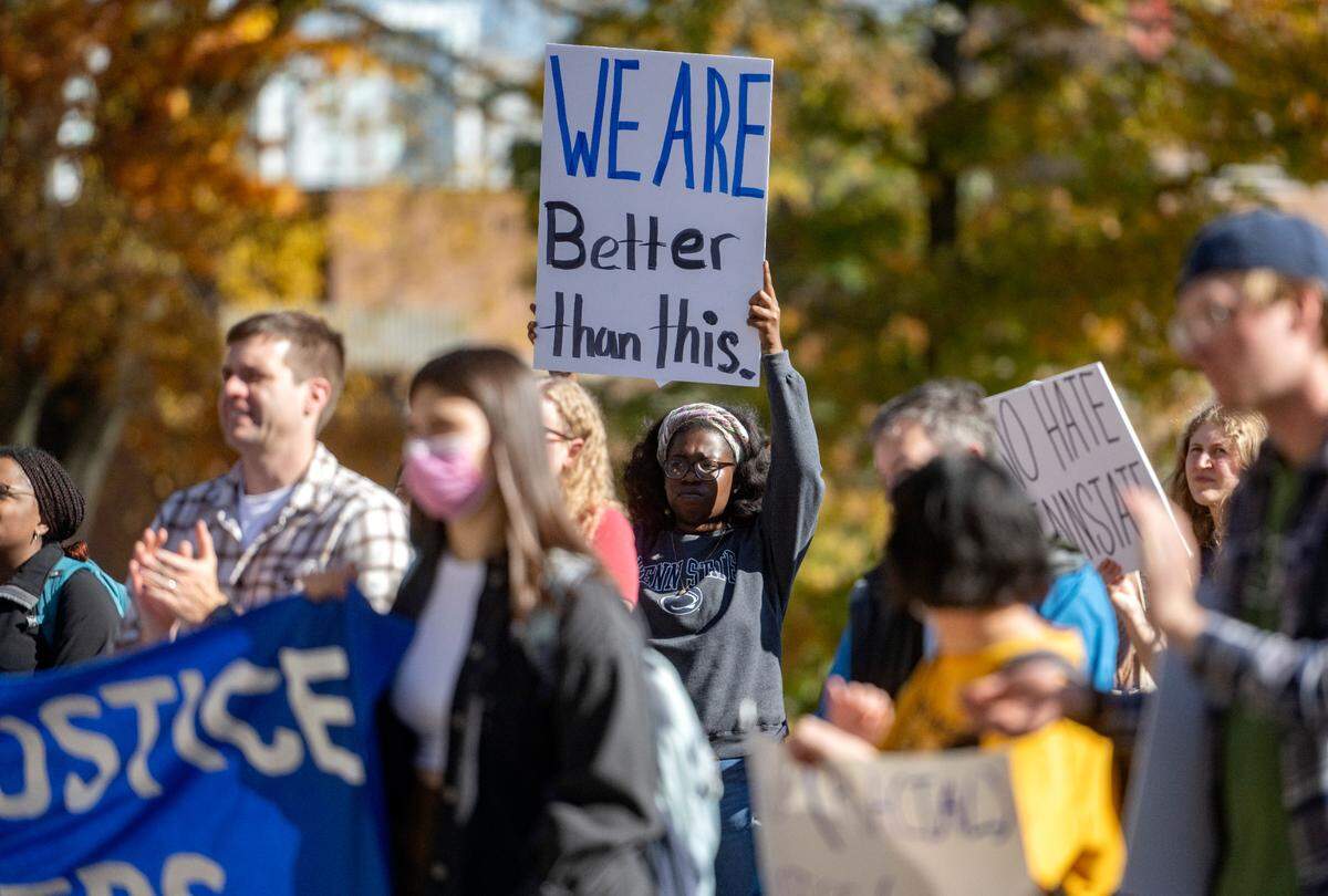 Signs, including one that reads, “We are better than this” are held up to Old Main during the “We Believe in Anti-Racism and Racial Justice at Penn State” rally Thursday hosted by a committee of concerned Penn State faculty.