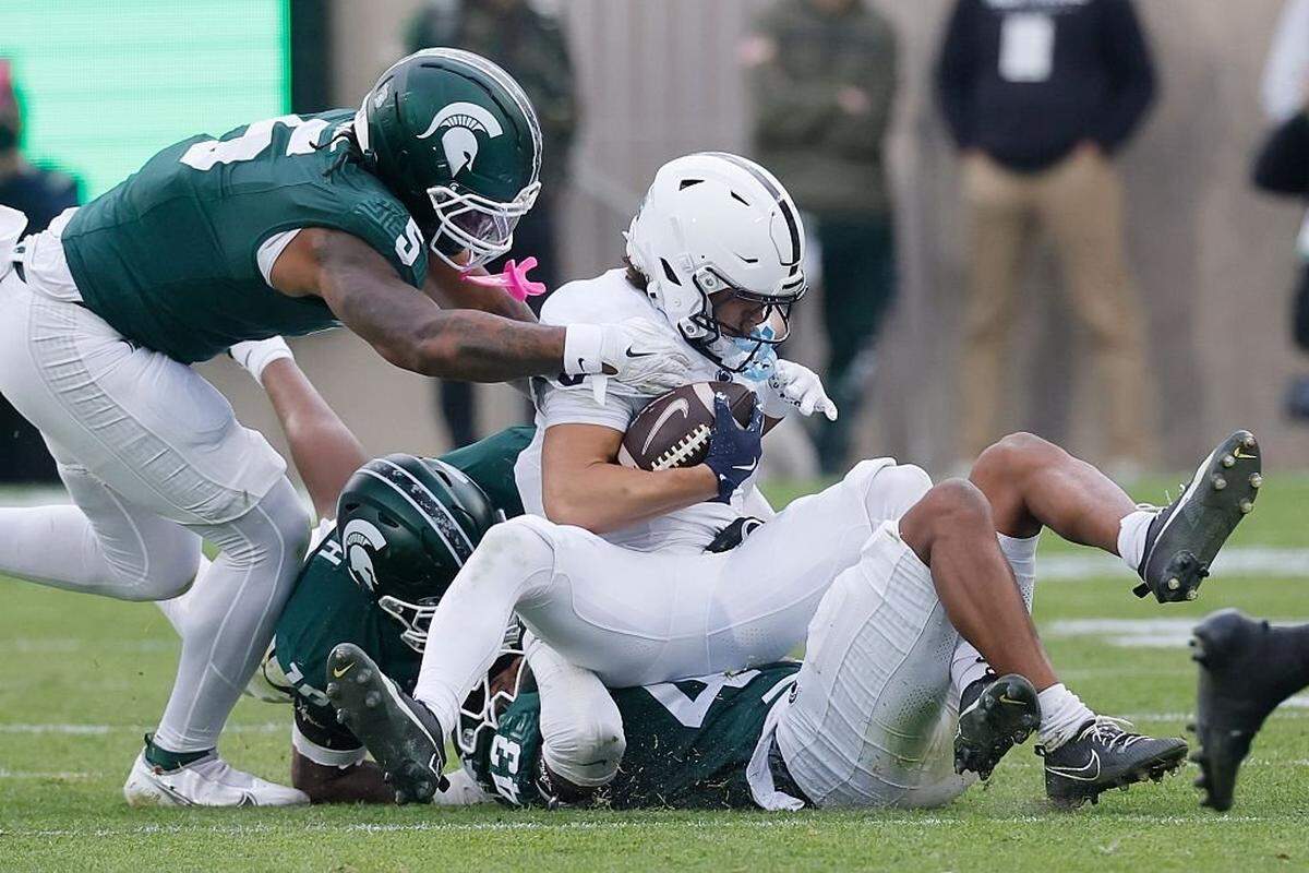 EAST LANSING, MICHIGAN - NOVEMBER 15: Malik Spencer #43 of the Michigan State Spartans and Jordan Hall #5 of the Michigan State Spartans tackle Trebor Pena #8 of the Penn State Nittany Lions during the first half at Spartan Stadium on November 15, 2025 in East Lansing, Michigan. (Photo by Duane Burleson/Getty Images)