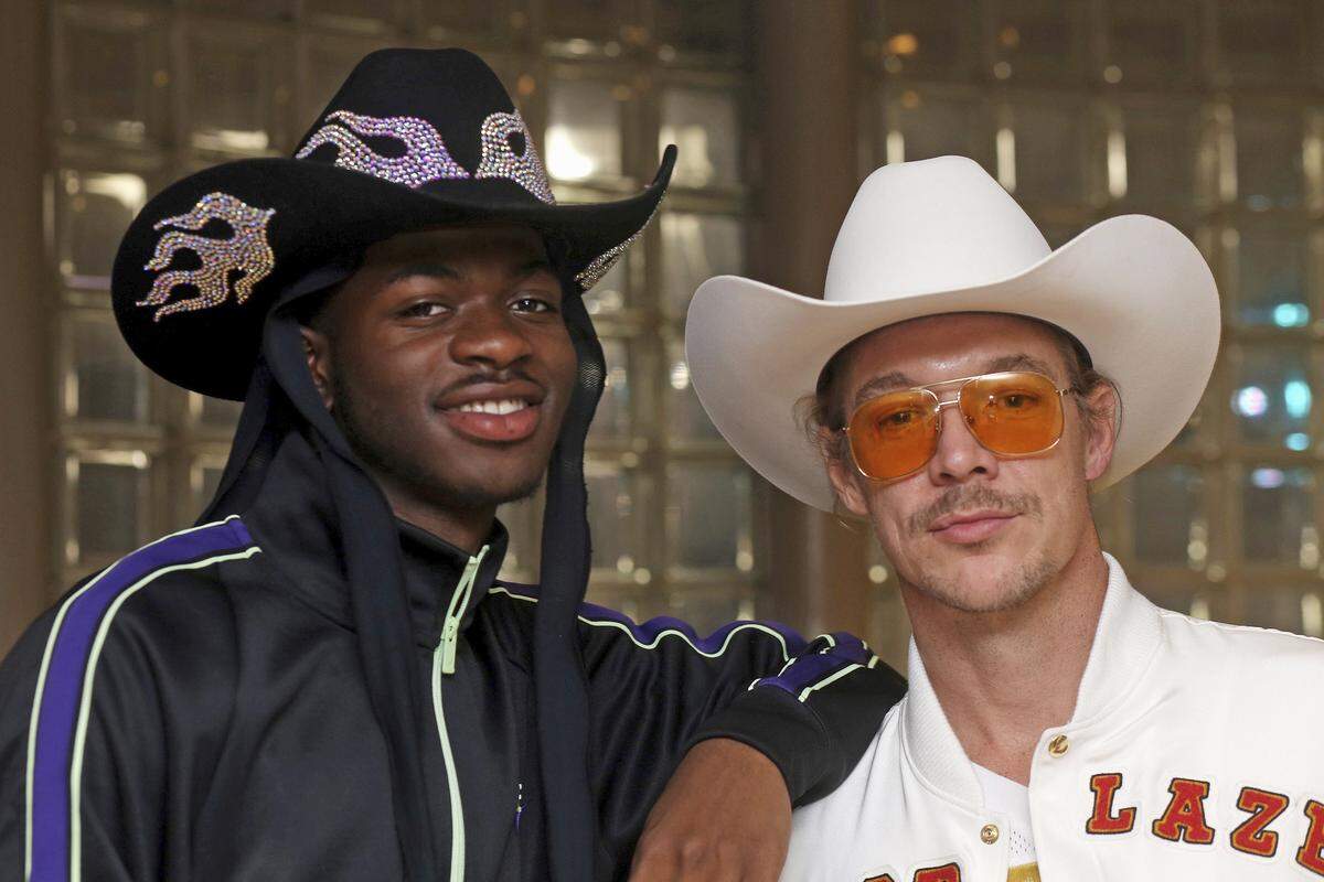 Grammy-winning recording artists Lil Nas X, left, and Diplo pose for a photograph at the NFL Super Bowl 54 football game in Miami Gardens, Fla., Sunday, Feb. 2, 2020. DJ-producer Diplo and rapper Lil Nas X, who stars in a Super Bowl commercial for Doritos, chatted in a suite at Hard Rock Stadium while watching the game. The pair, both sporting large cowboy hats Sunday, collaborated on a remix of “Old Town Road,” which is the longest-running No. 1 song in the history of Billboard’s Hot 100 chart. (AP Photo/John Carucci)