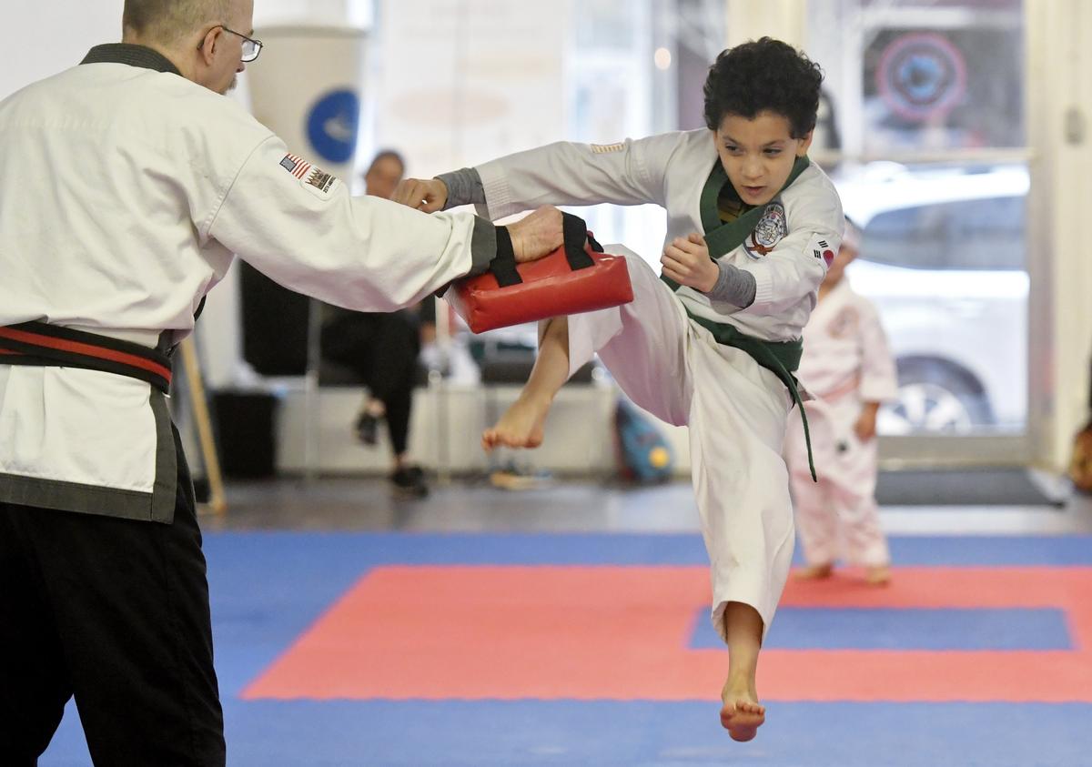 Jeffery Lynch, 9, works on his jump kicks with Tang Soo Do Master Terry Summers at Summers Martial Arts on Monday.