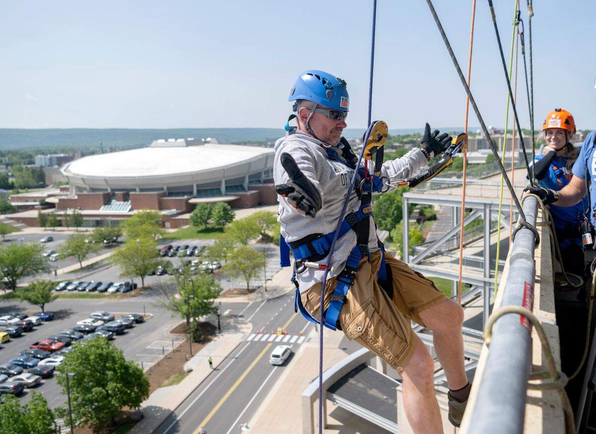 Bryan Wooster poses for a photos as he gets ready to rappel down the side of Beaver Stadium for the Centre County United Way Over the Edge fundraiser on Friday, May 19, 2023.