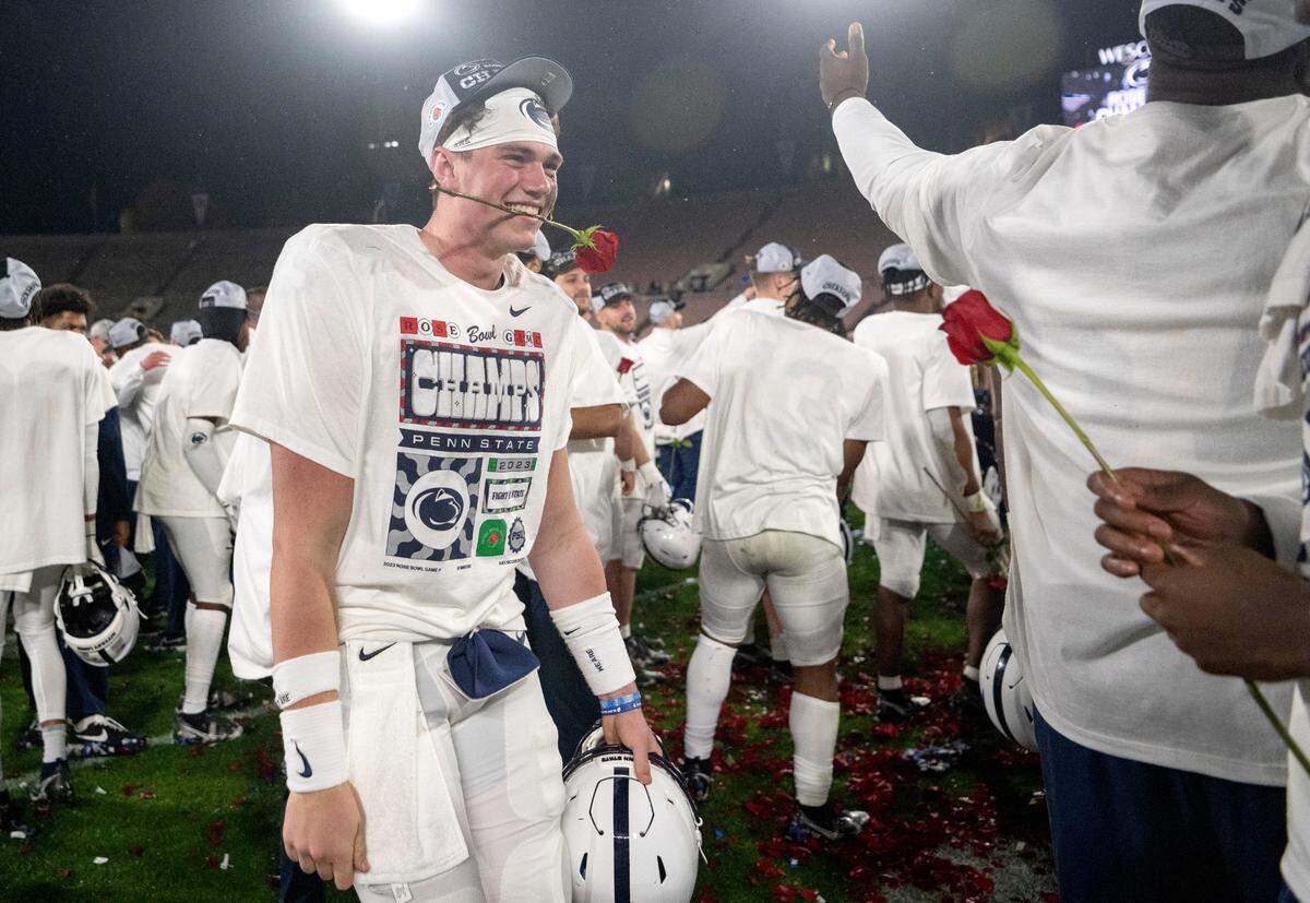 Penn State quarterback Drew Allar bites a rose as he and his teammates celebrate the 35-21 win over Utah in the Rose Bowl on Monday, Jan. 2, 2023.