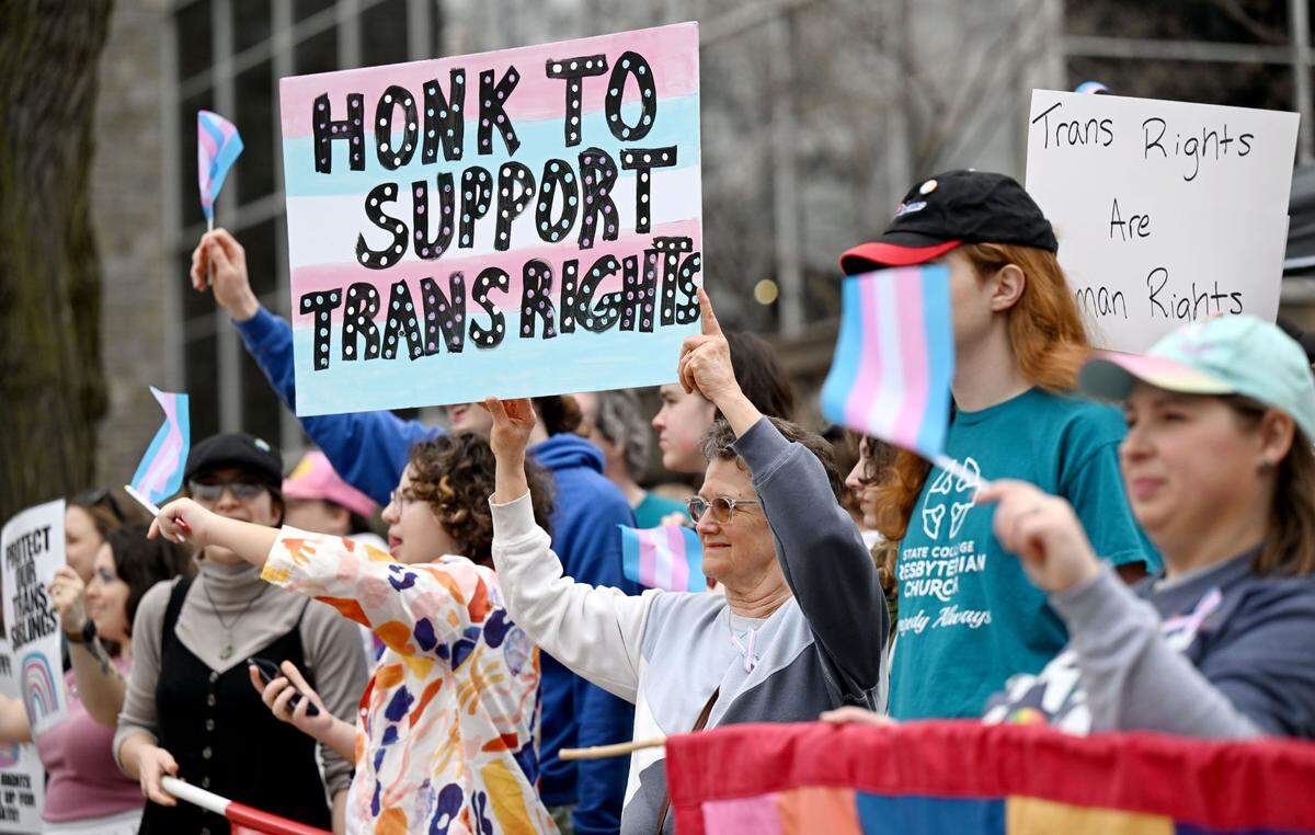 Kerry Weissmann holds a sign that reads “honk to support trans rights” during the Centre LGBT+’s Transgender Day of Visibility at the Allen Street gates on Monday, March 31, 2025.