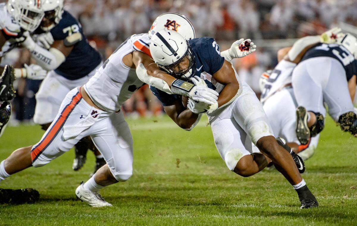 Penn State running back Noah Cain pushes an Auburn defender into the end zone for a touchdown.