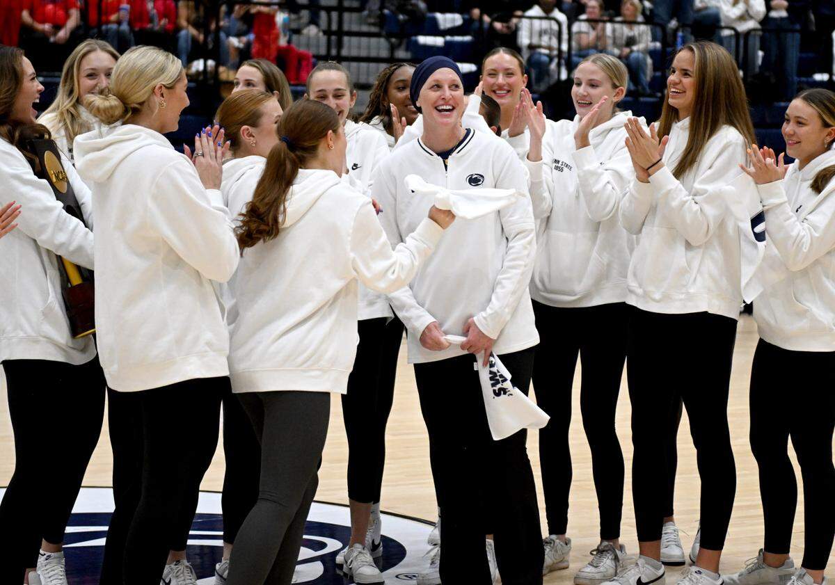 Penn State’s women’s volleyball coach Katie Schumacher-Cawley is applauded by her players as the team is recognized during the men’s basketball game in Rec Hall on Thursday, Jan. 30, 2025.