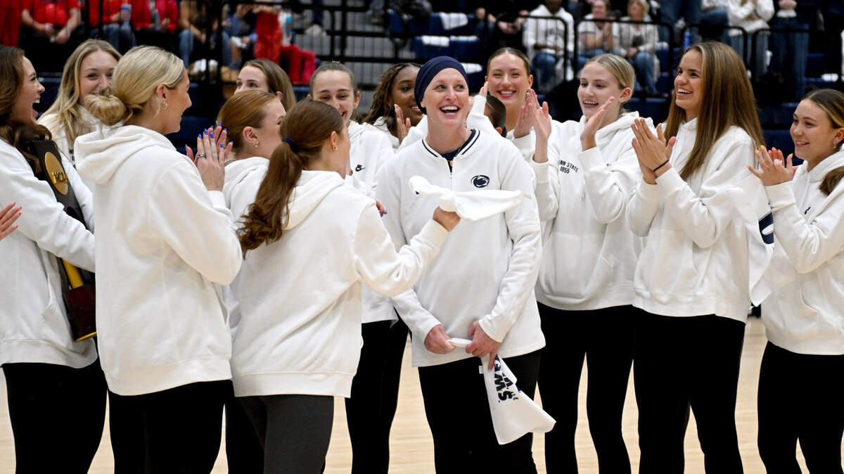 Penn State’s women’s volleyball coach Katie Schumacher-Cawley is applauded by her players as the team is recognized during the men’s basketball game in Rec Hall on Thursday, Jan. 30, 2025.