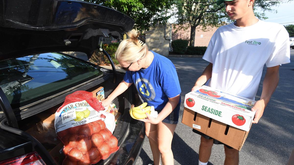 Luke Fey and Denise Fey of Fest Zero organize leftover food from vendors at Arts Fest to donate in downtown State College.