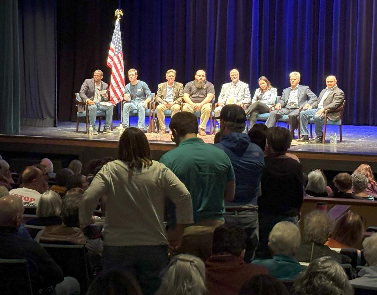 Attendees of the People’s Town Hall line up for questions in The State Theatre while the seven-person panel (and moderator) sit on stage. The town hall was organized by the Centre County Democrats.
