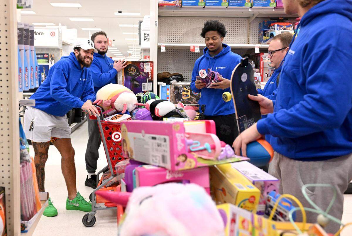 Penn State football players compare their shopping carts as they help West Shore Home shop for Toys for Tots on Monday, Dec. 2, 2024 at Target.
