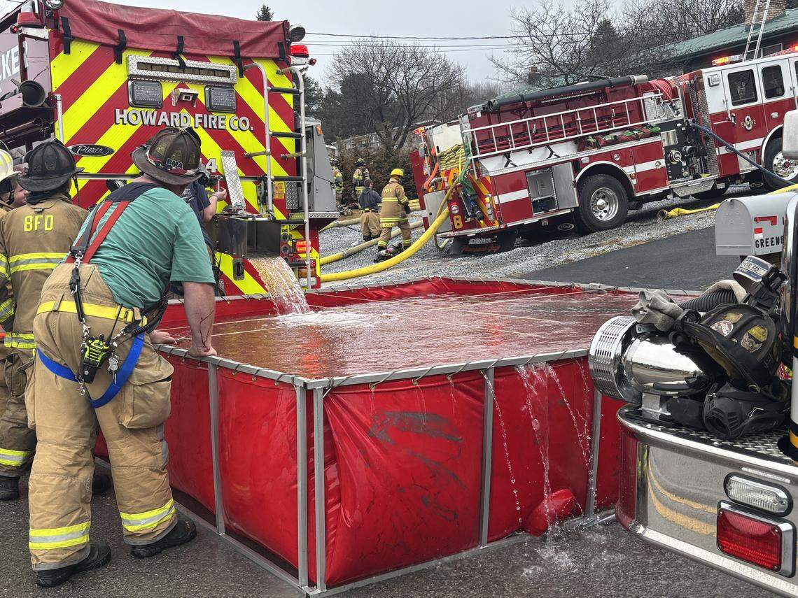 Firefighters tend to a tanker shuttle Saturday, March 7, 2026, in the 100 block of Greens Valley Road because there were no nearby hydrants during a house fire.