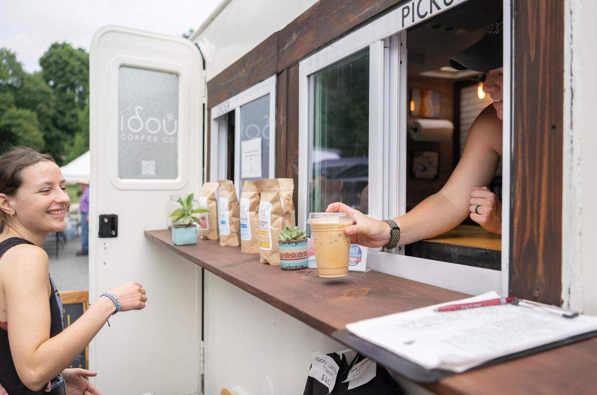 Mikala Swanson serves a drink from the Idou Coffee Co. trailer at the Downtown Farmers Market on Friday, July 29, 2022.