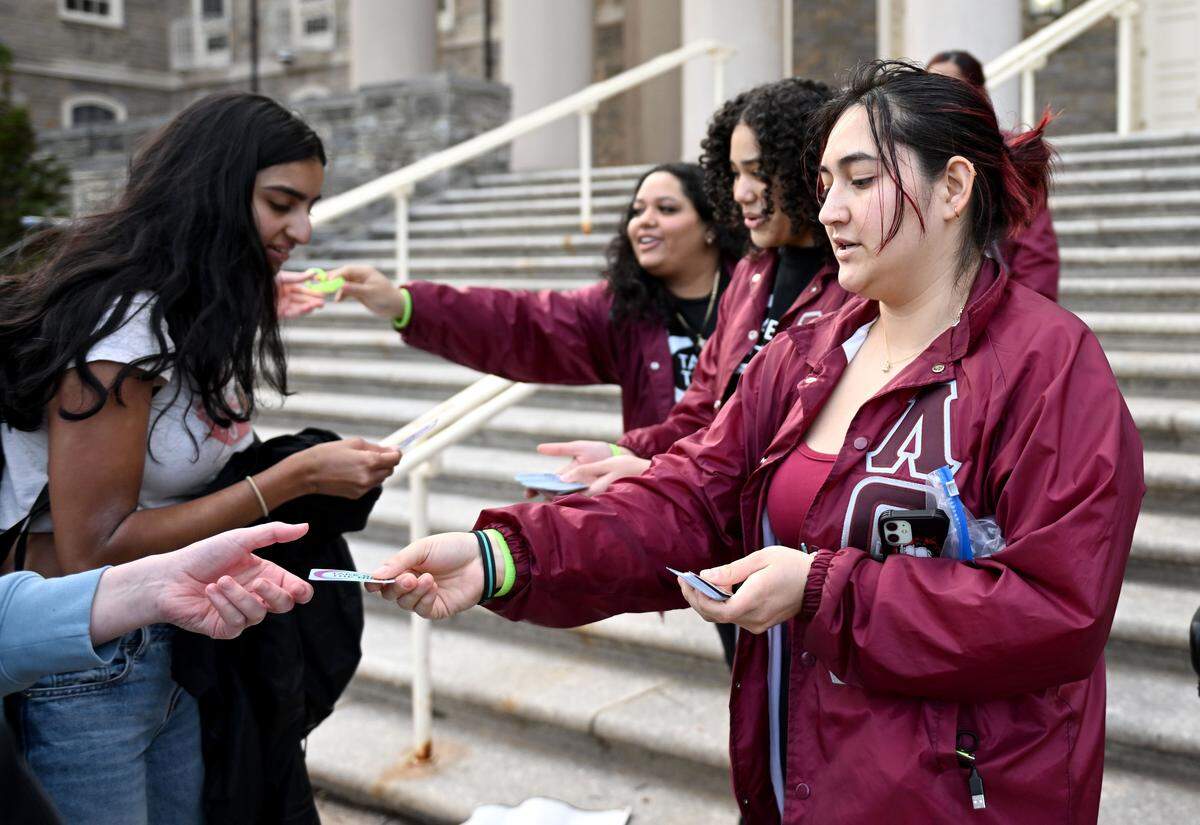 Members of Lambda Theta Alpha hand out glow bracelets and stickers for “Take Back the Night” on Wednesday, April 1, 2026 in front of Old Main. 