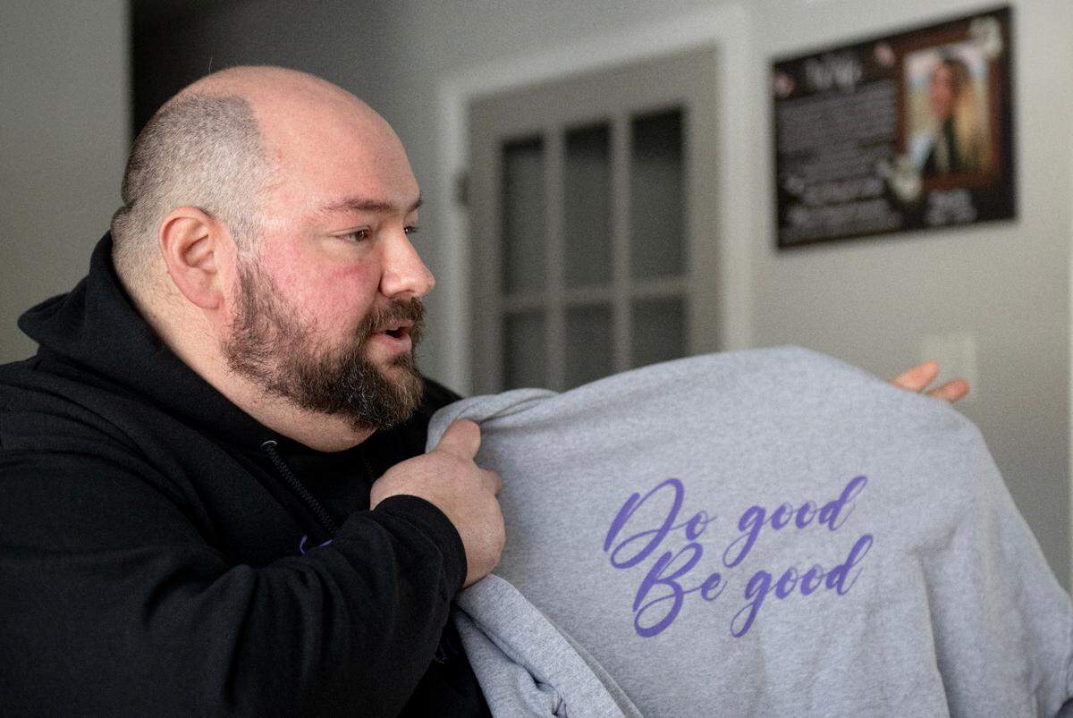 Walt Derhammer shows a sweatshirt for Koleton Cares with the phrase “Do Good, Be Good” written on the back. Derhammer is creating the nonprofit to help new and expecting mothers in honor of his late wife and son.