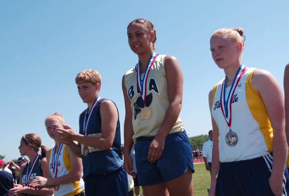 Bald Eagle’s Angela Hoover stands on the podium after receiving her 4th consecutive gold medal in the girls javelin during the 2004 PIAA Track & Field Championships in Shippensburg. May 29,2004.