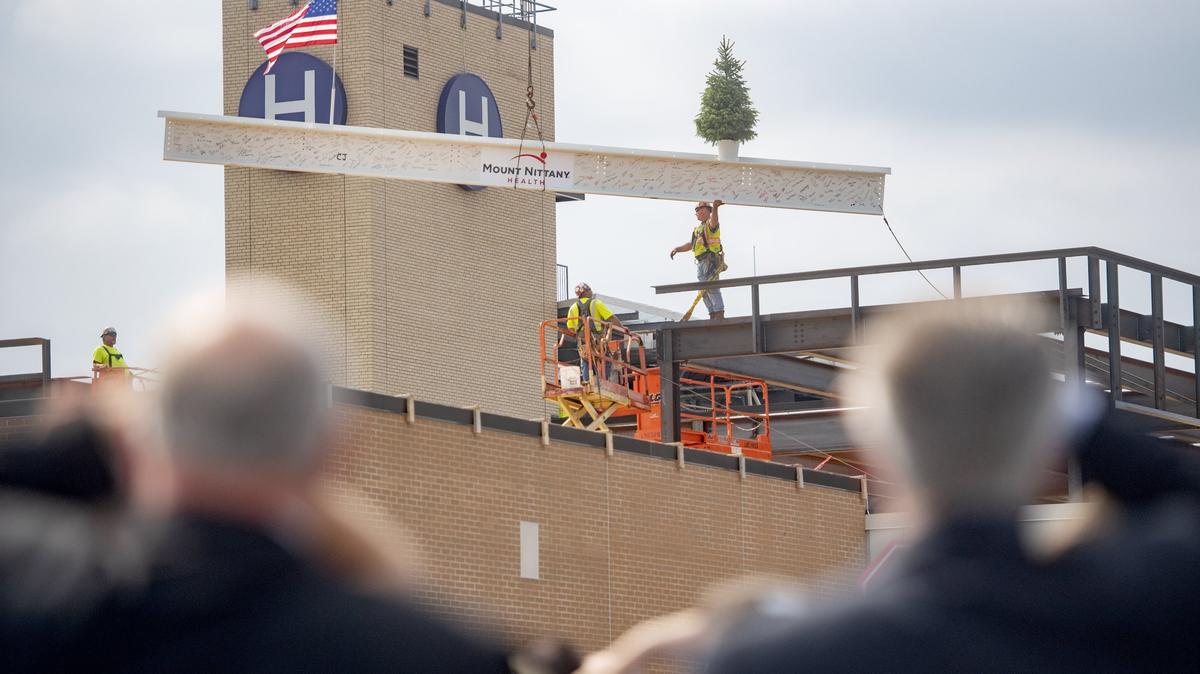Hospital employees, financial donors and members of the community watch the final steel beam in the construction of the new cardiovascular pavilion at Mount Nittany Medical Center be placed during a ceremony on Friday, August 10, 2018.  