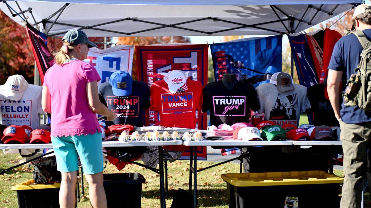 Donald Trump supporters look at merchandise before the“Team Trump” bus tour stops in Centre County Oct. 22, 2024. Can you wear political gear to the polls on Election Day? Here’s what Pennsylvania guidelines say.