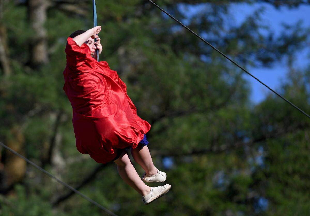 Addie Stine waves to the crowd as she zip lines over for the Grace Prep graduation on Friday, June 2, 2023 at Camp Kanesatake.