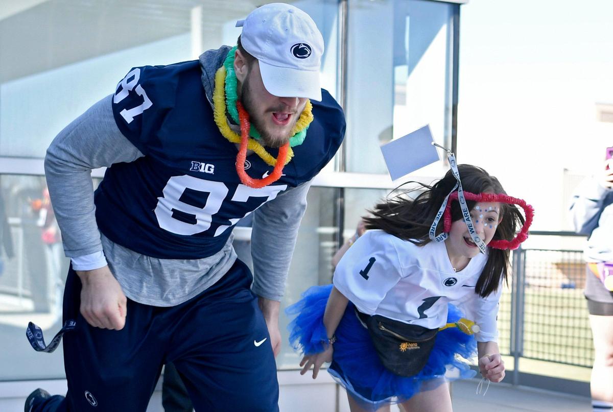 Penn State tight end Pat Freiermuth races Ashlyn Brysiak, 12, on the patio of the Lasch Building on Saturday, Feb. 22, 2020.