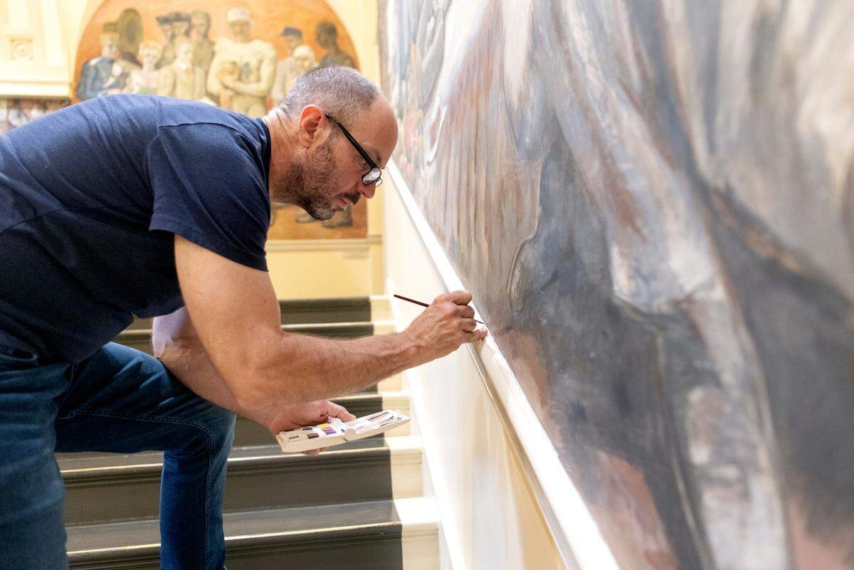 Jeff Johnson touches up the edge of the fresco in Old Main on Tuesday, June 14, 2022.
