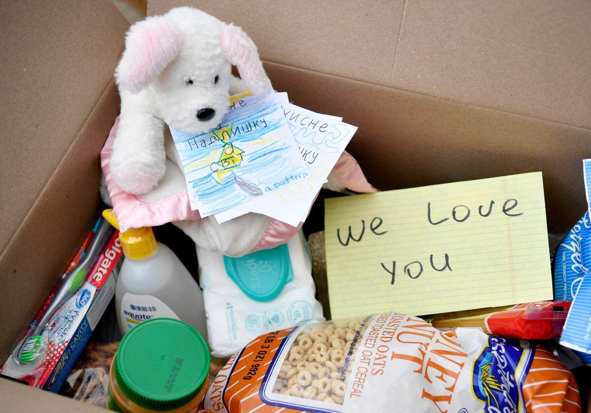 Hand written notes, baby items, food and flashlights are among the items being packed into boxes to be sent to those in need in Ukraine.