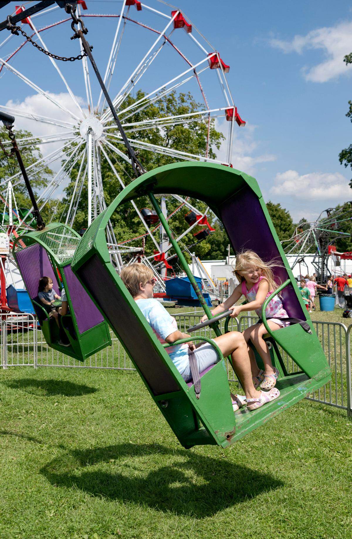 Savanna, 5, laughs with her grandmother Sandy as they spin on a ride at the Centre County Grange Encampment and Fair on Friday, Aug. 18, 2023.  