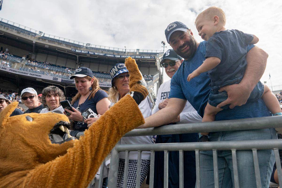 The Penn State Nittany Lion high fives a young fan during the Penn State Blue-White game on Saturday, April 15, 2023.