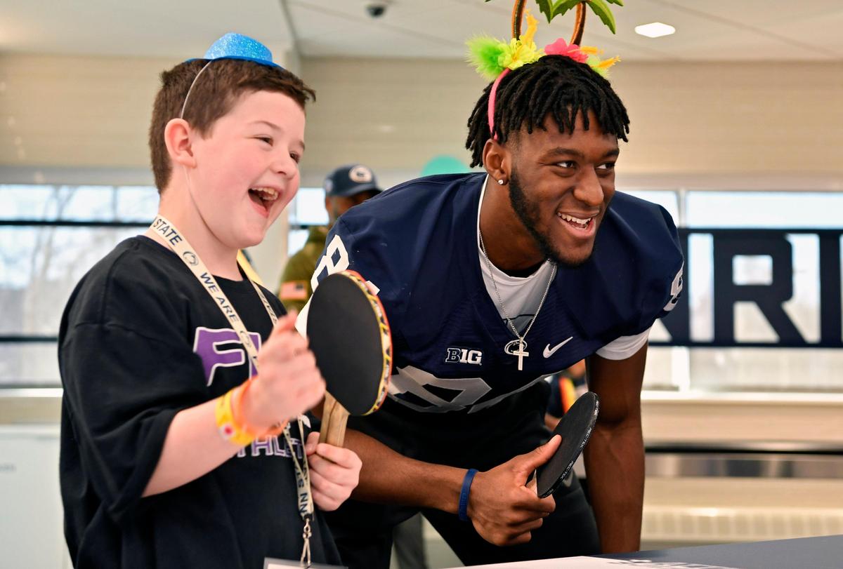 Nicholas Baptiste, 7, laughs as he plays pingpong with Penn State wide receiver Benjamin Wilson in the Lasch Building on Saturday, Feb. 22, 2020.