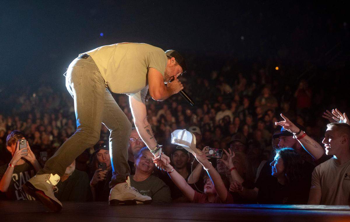 A fan holds a hat out to be autographed as Walker Hayes performs at the Bryce Jordan Center as part of the Duck Buck Tour on Thursday, April 27, 2023.