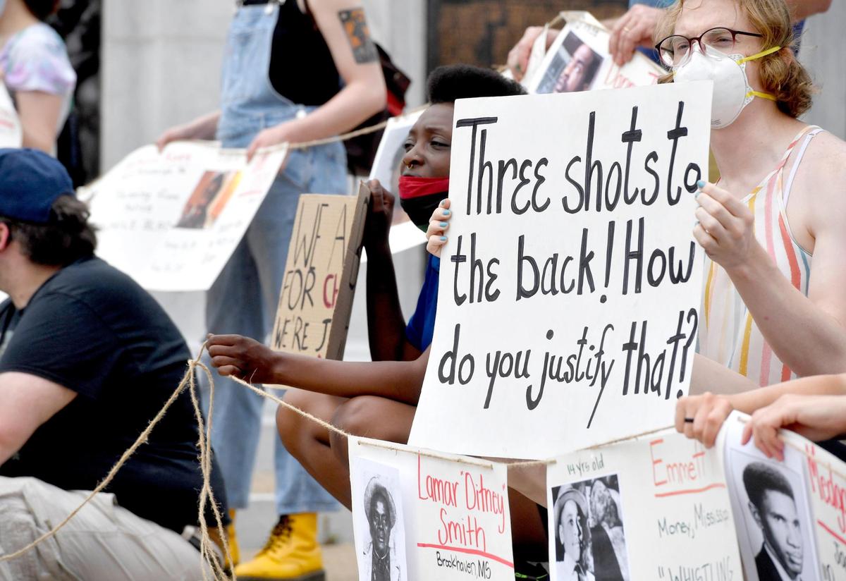 A protester holds a sign about the Osaze Osagie shooting, “Three shots to the back how do you justify that.” Community members gathered outside of the Centre County Courthouse in Bellefonte Tuesday as the 3/20 Coalition continues to push for the release of the names of officers involved in Osagie’s March 2019 death.