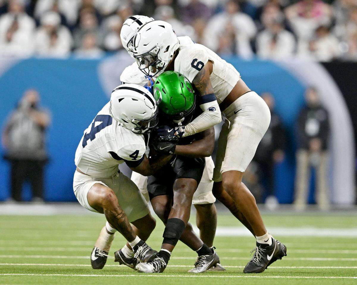 Penn State cornerback A.J. Harris and safety Zakee Wheatley stop Oregon’s Noah Whittington during the Big Ten Championship game at Lucas Oil Stadium on Saturday, Dec. 7, 2024.  