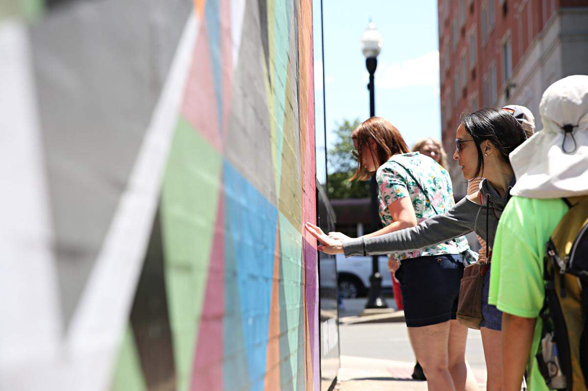 Visitors check out the Wild Geese Mural by Willian Snyder III in downtown State College.