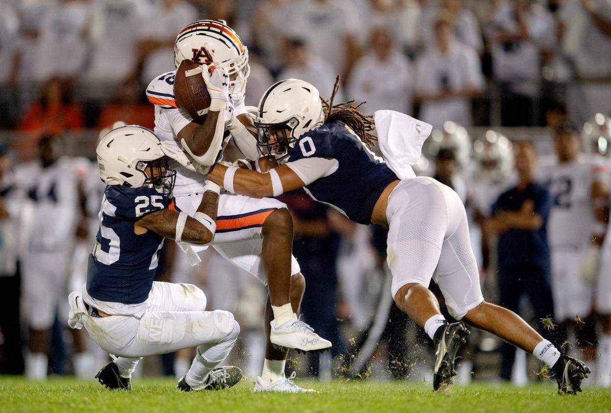 Penn State cornerback Daequan Hardy and safety Jonathan Sutherland stop Auburn’s Malcolm Johnson Jr. during the game.
