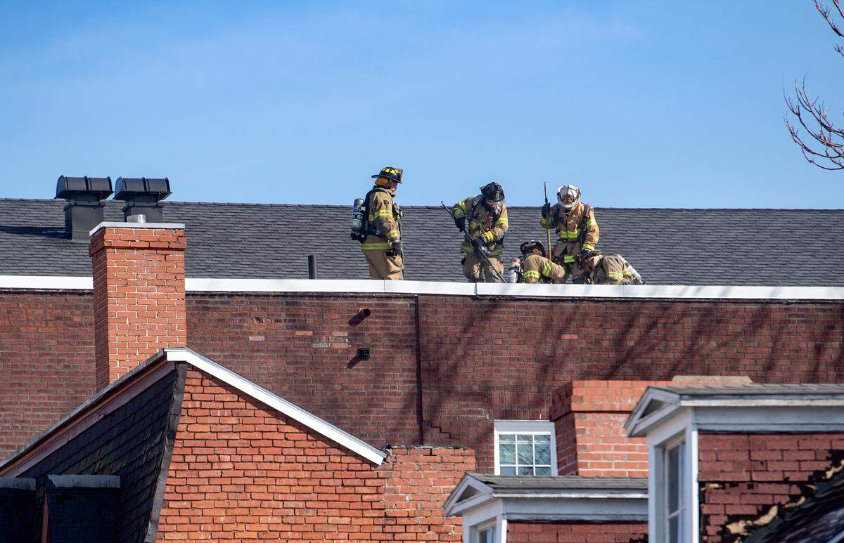 Firefighters work on the roof of the former Cadillac Building in downtown Bellefonte on Wednesday after reports of a fire in the attic.