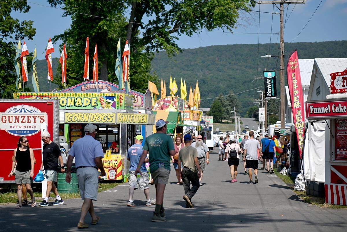 Visitors walk along some of the food vendors at the Centre County Grange Fair on Friday, Aug. 15, 2025.  