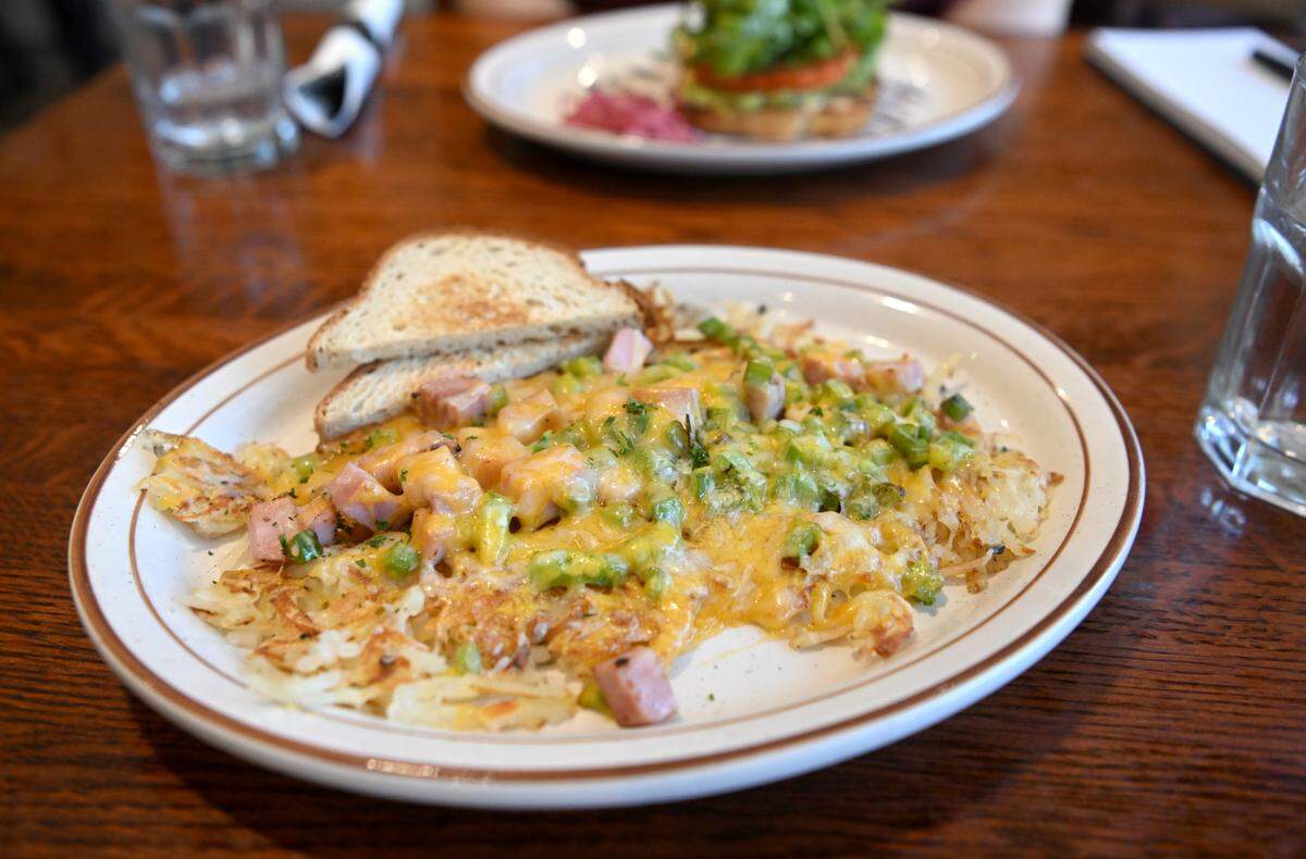 The hash platter, potato base topped with your choice of two toppings and covered with cheese, is served at Breakfast on Boal on Wednesday. The dish is served here with ham and green peppers and gluten-free toast.